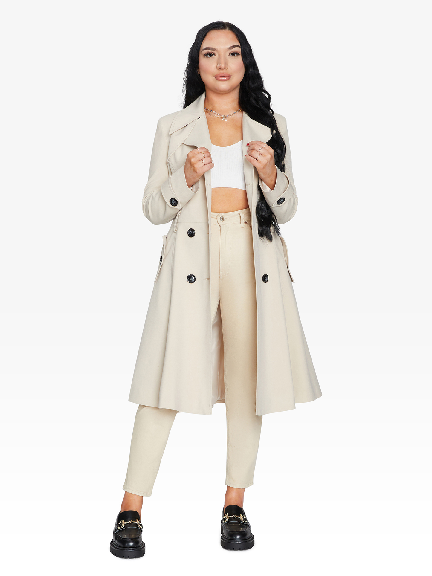 Woman wearing a beige trench coat on a white background