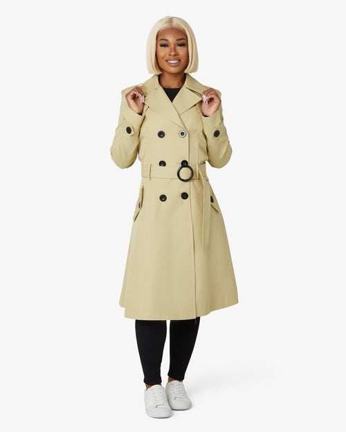 Person wearing a beige trench coat on a white background