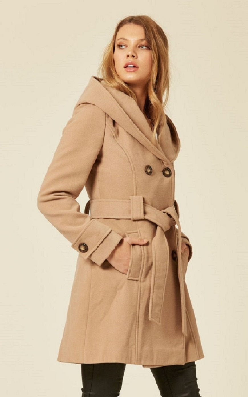 Woman wearing a beige coat on a plain background