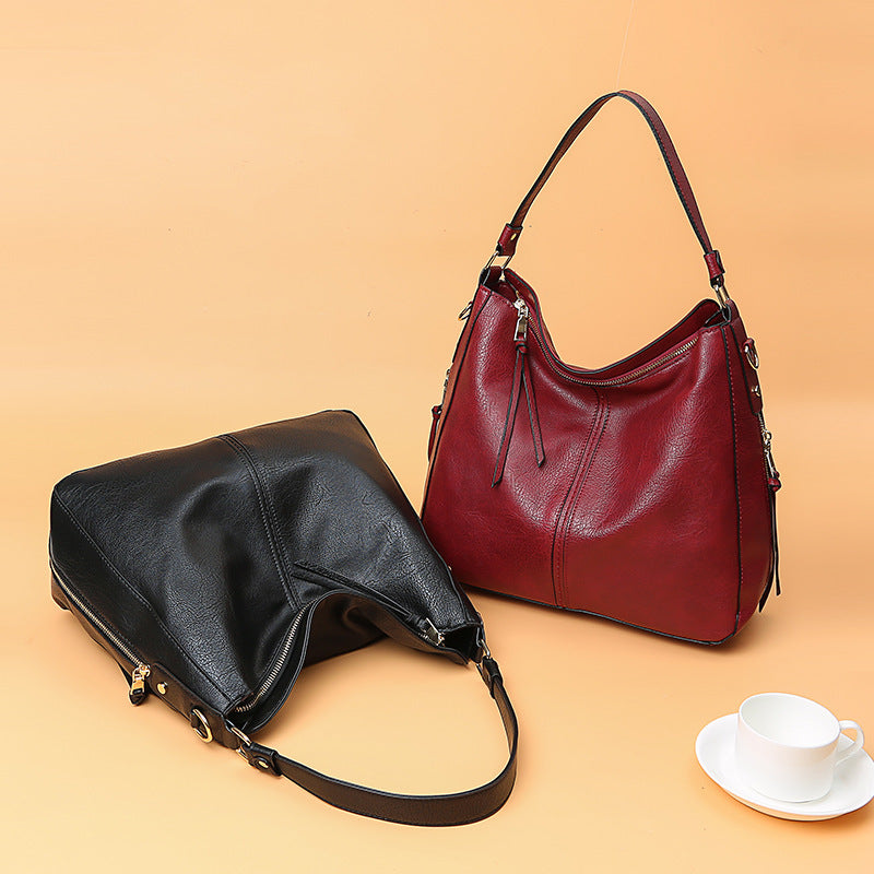 Black and red handbags on a beige background with a cup and saucer.