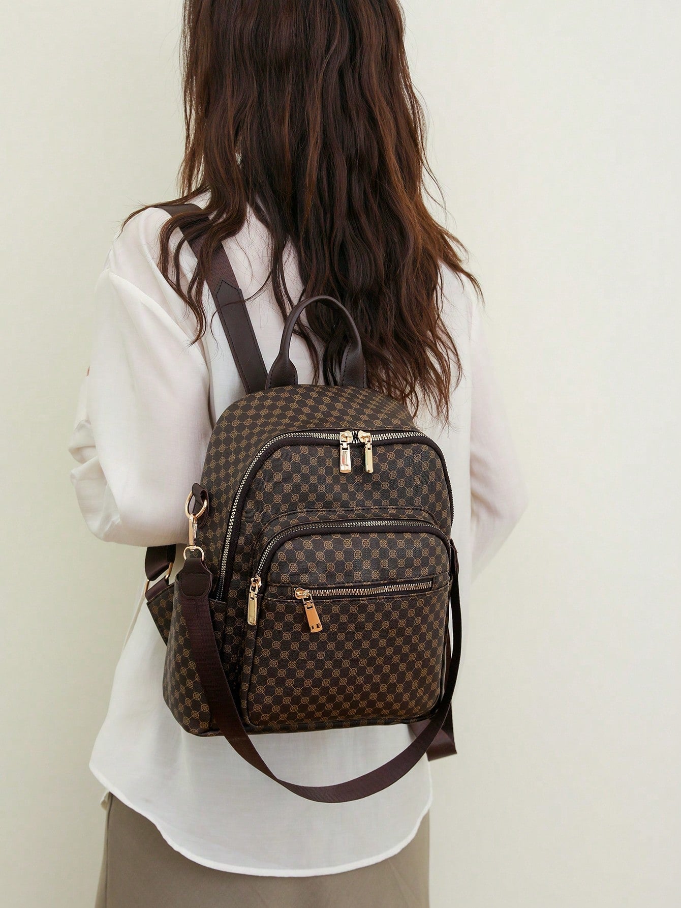 Person wearing a brown checkered backpack against a plain background