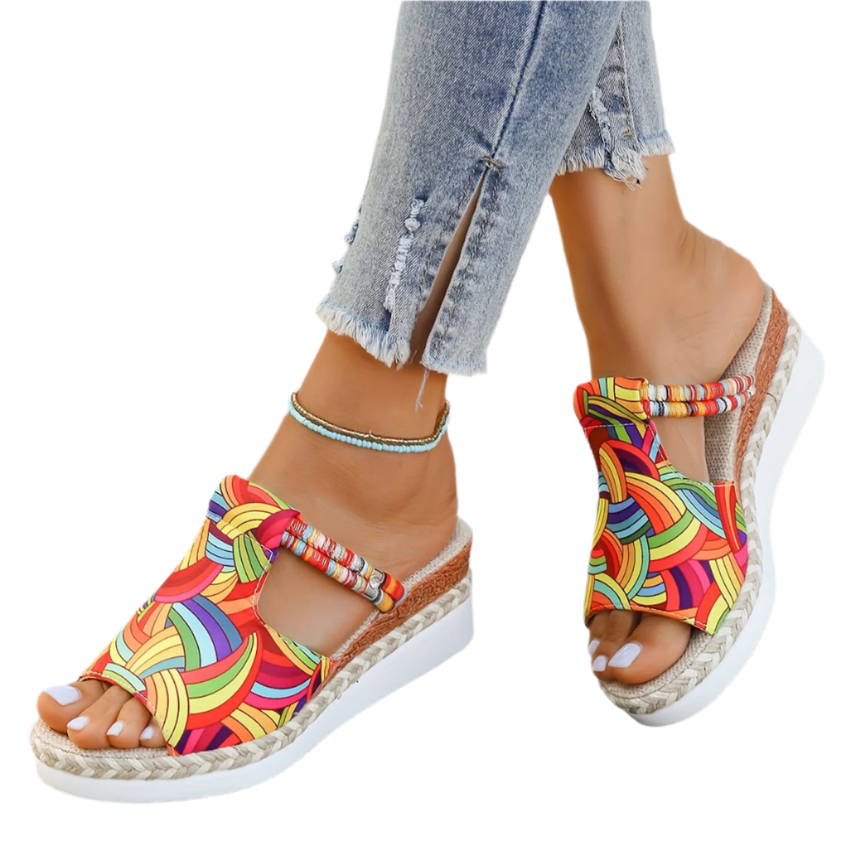 Colorful espadrille sandals worn with rolled-up jeans on a white background
