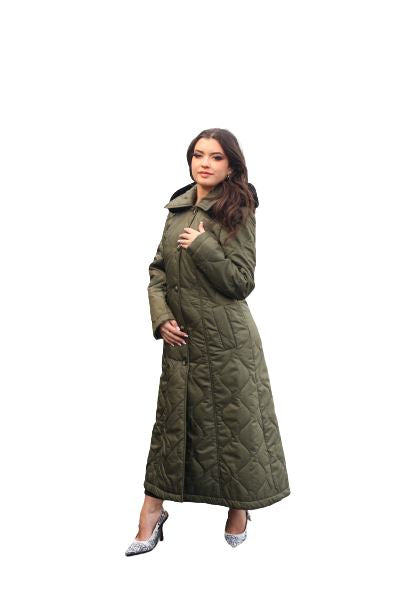Woman wearing a long quilted green coat on a white background
