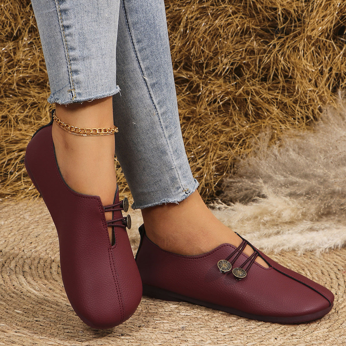 Maroon loafers worn with light blue jeans against a natural background