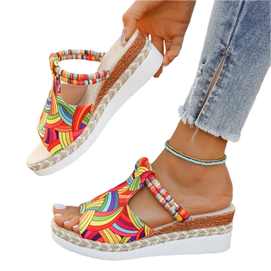 Colorful wedge sandals with espadrille sole worn by a person.