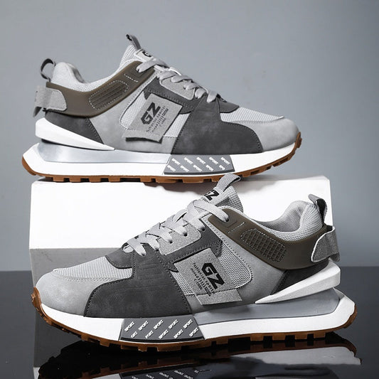 Gray and brown sneakers with 'GZ' logo on a reflective surface and gray background