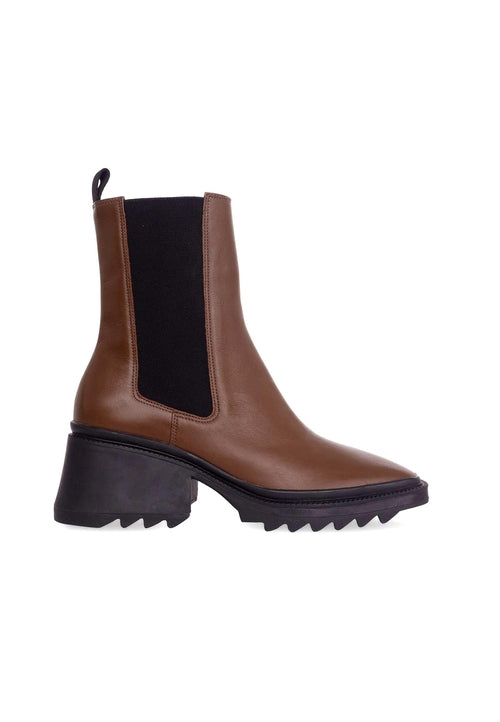 Brown Chelsea boot with black sole on a white background