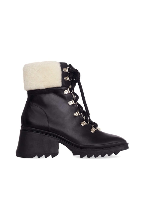 Black leather boot with white fur lining on a white background