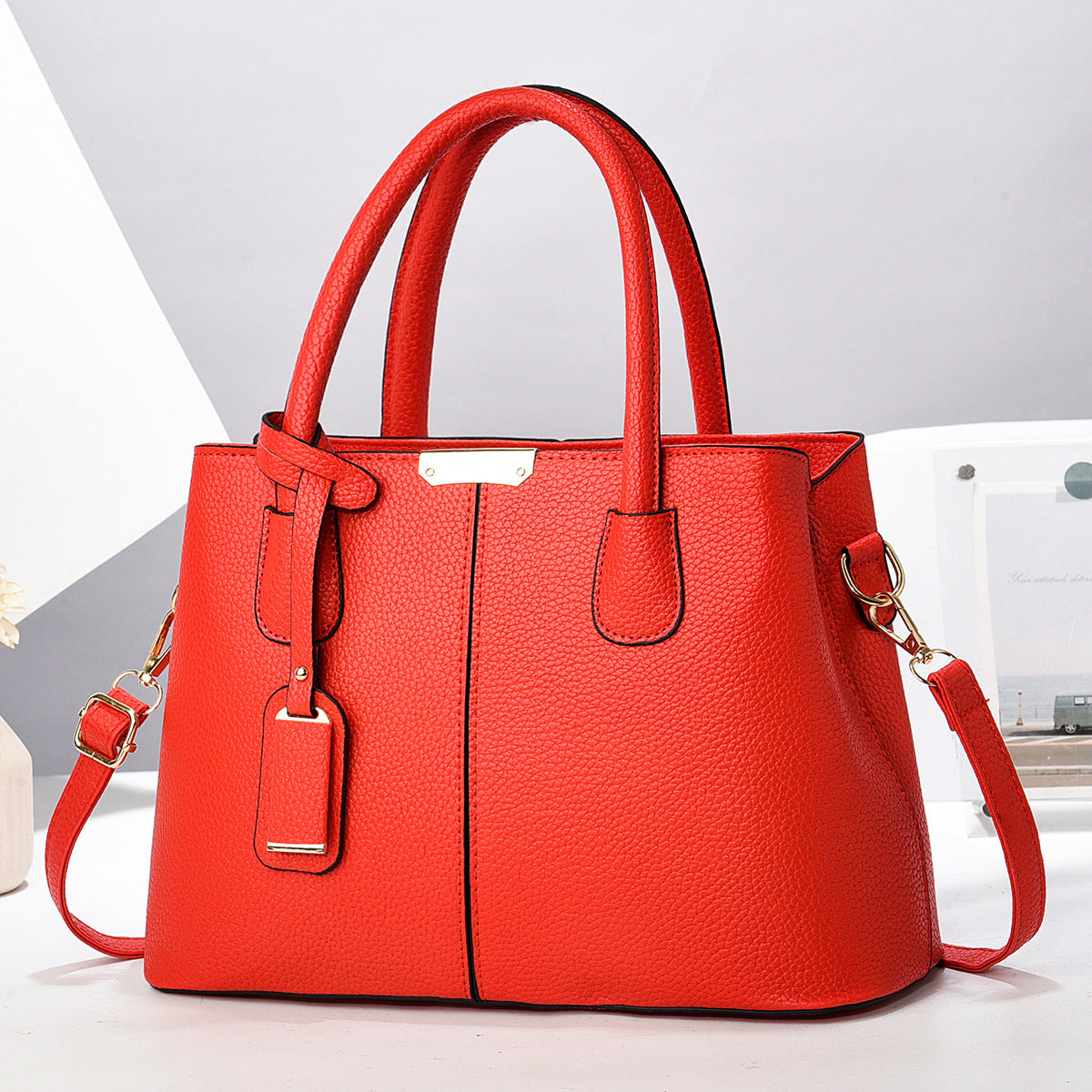 Red handbag with gold accents on a light gray background