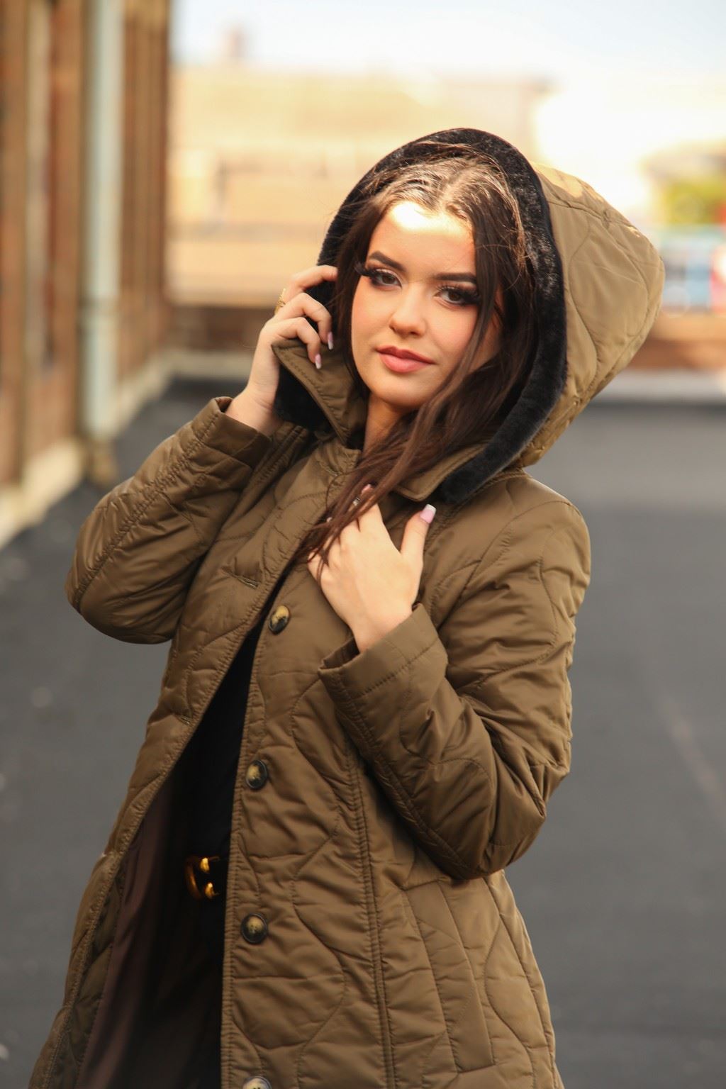 Woman wearing a brown hooded coat outdoors