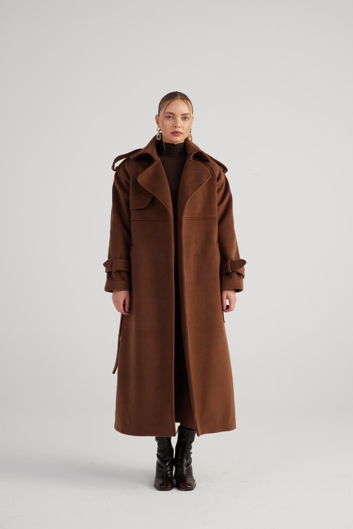 Woman wearing a brown coat on a white background