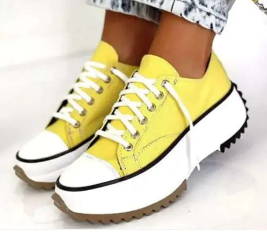 Yellow sneakers with white soles on a light background