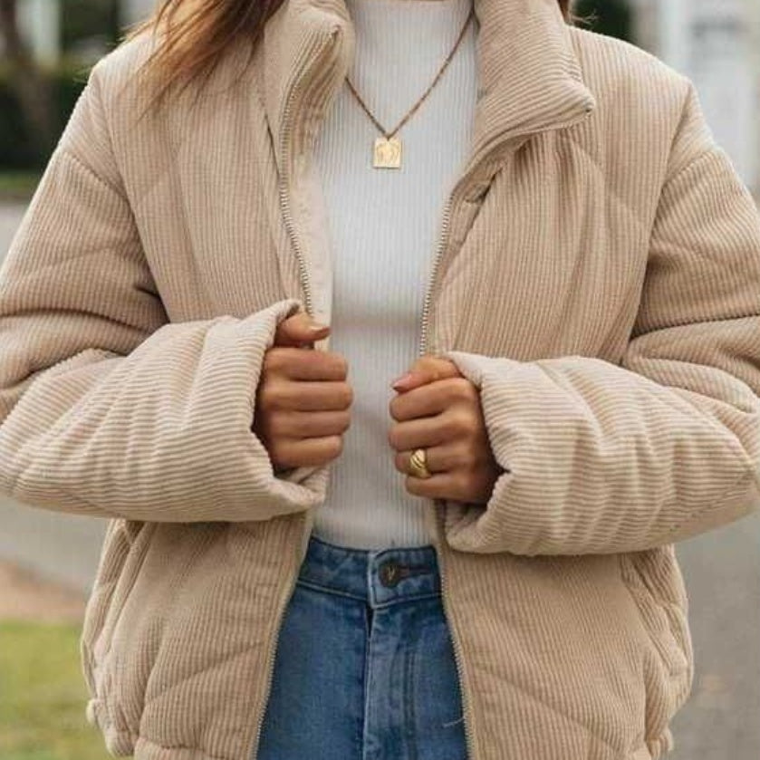 Person wearing a beige corduroy jacket with a blurred background