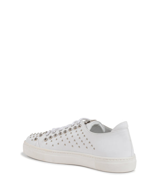 White sneaker with studded details on a white background