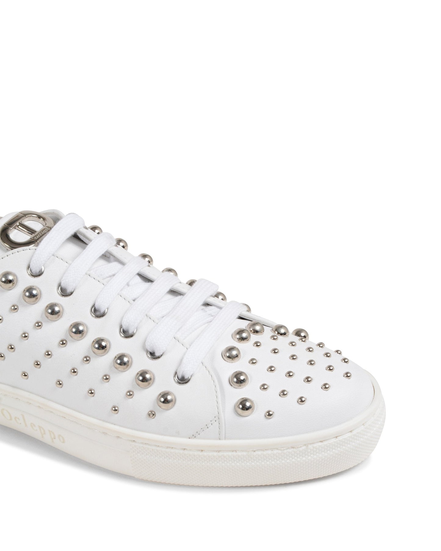 White sneaker with silver studs on a white background
