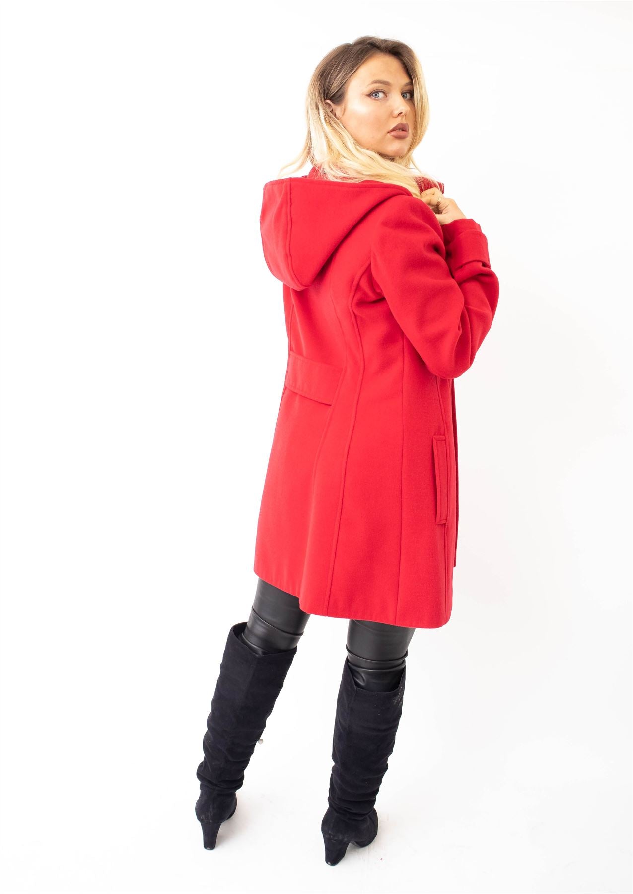 Woman wearing a red coat and black boots on a white background