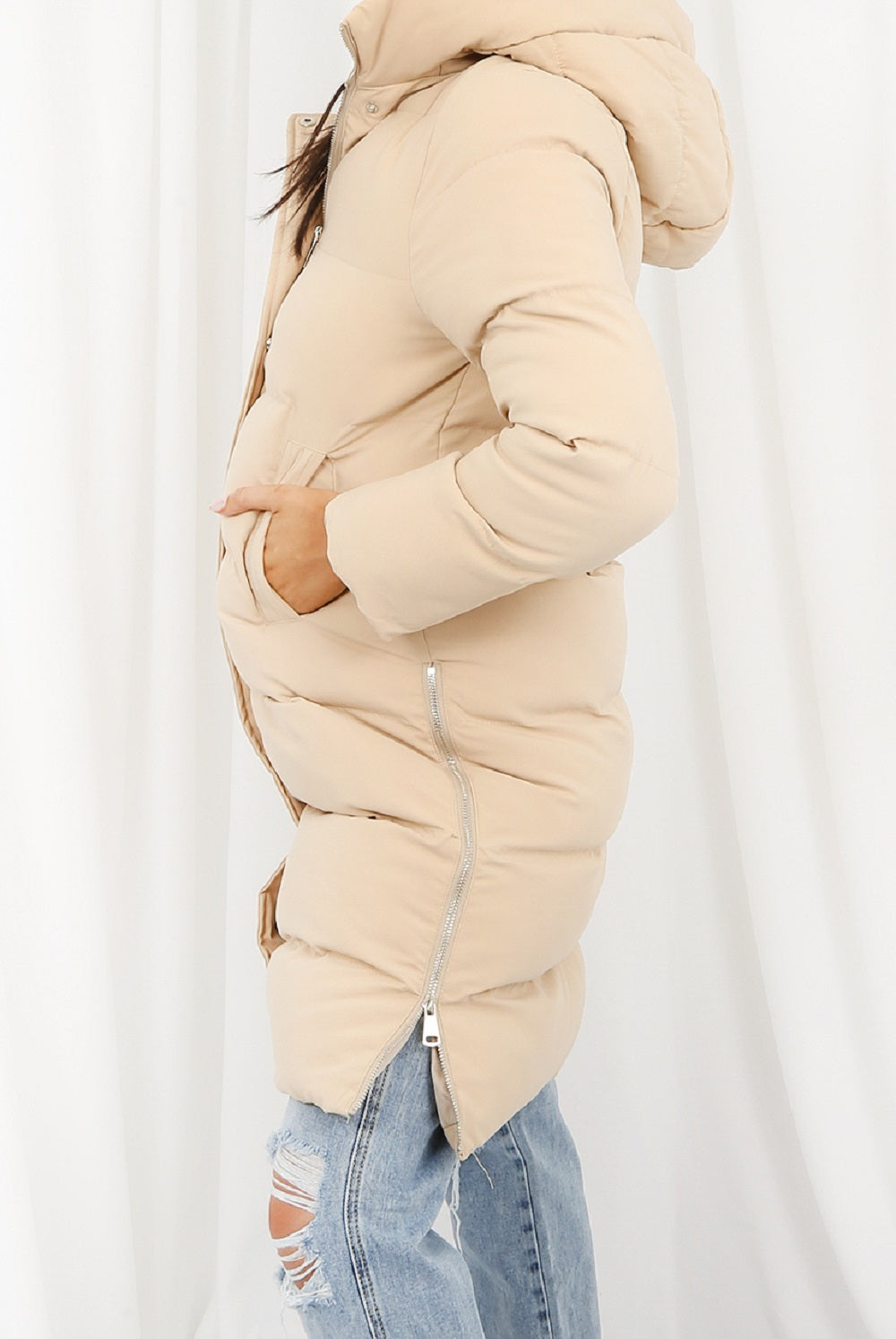 Beige puffer jacket worn by a person on a white background