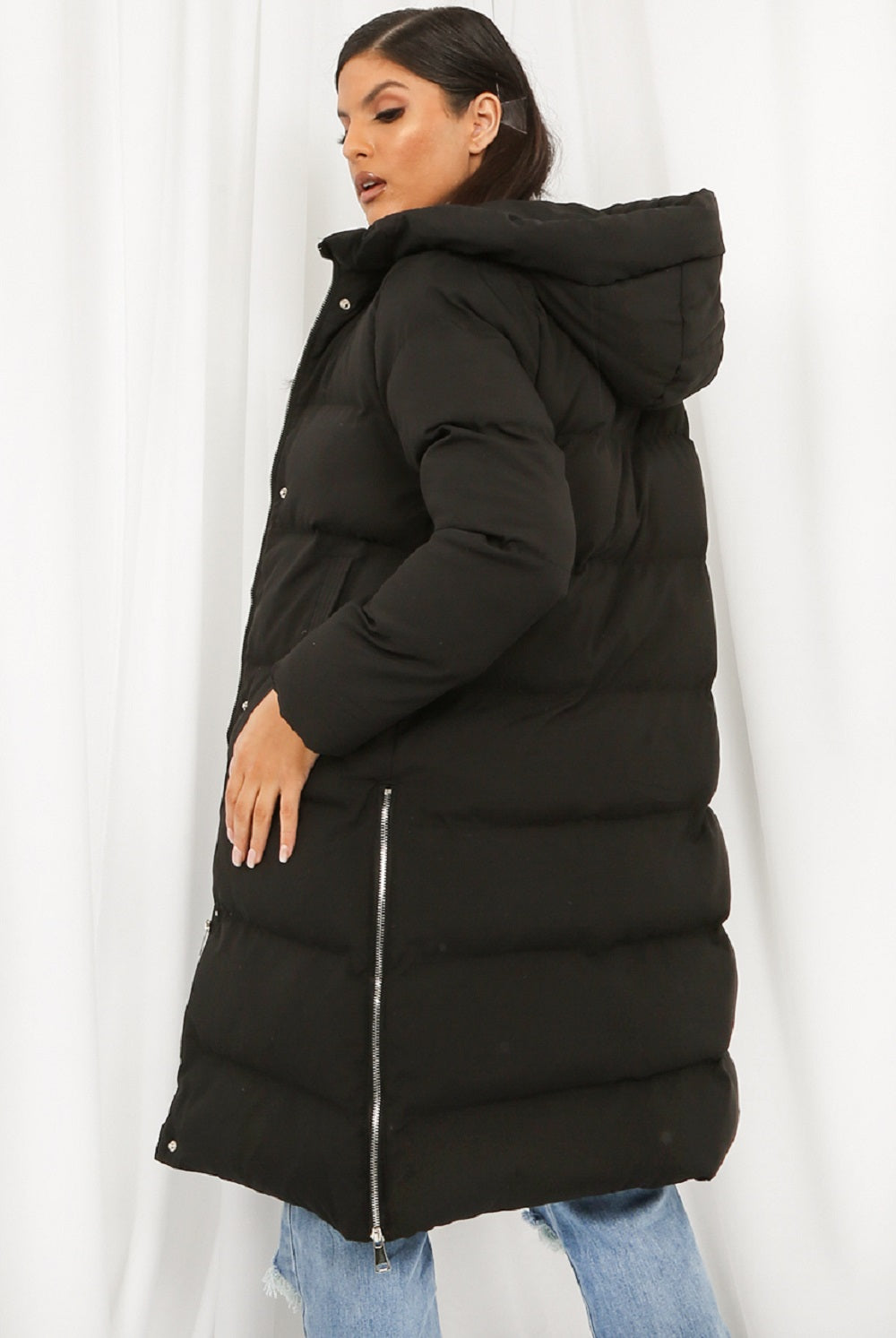 Person wearing a black puffer jacket against a white background
