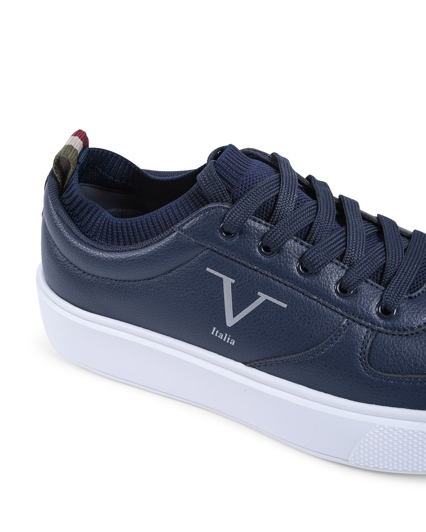 Navy blue sneaker with a white sole on a light gray background