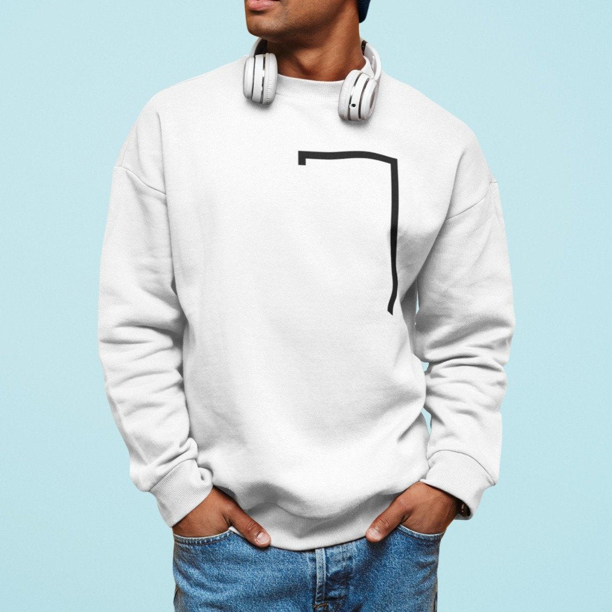 Person wearing a white sweatshirt with a black design on a light blue background