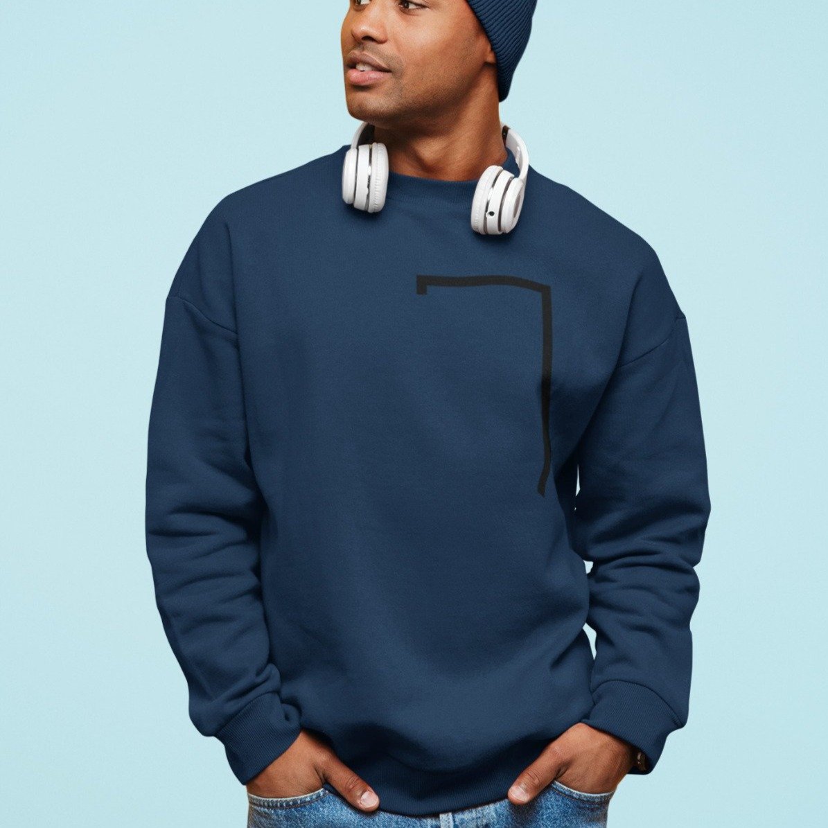 Man wearing a navy blue sweatshirt with a geometric design on a light blue background