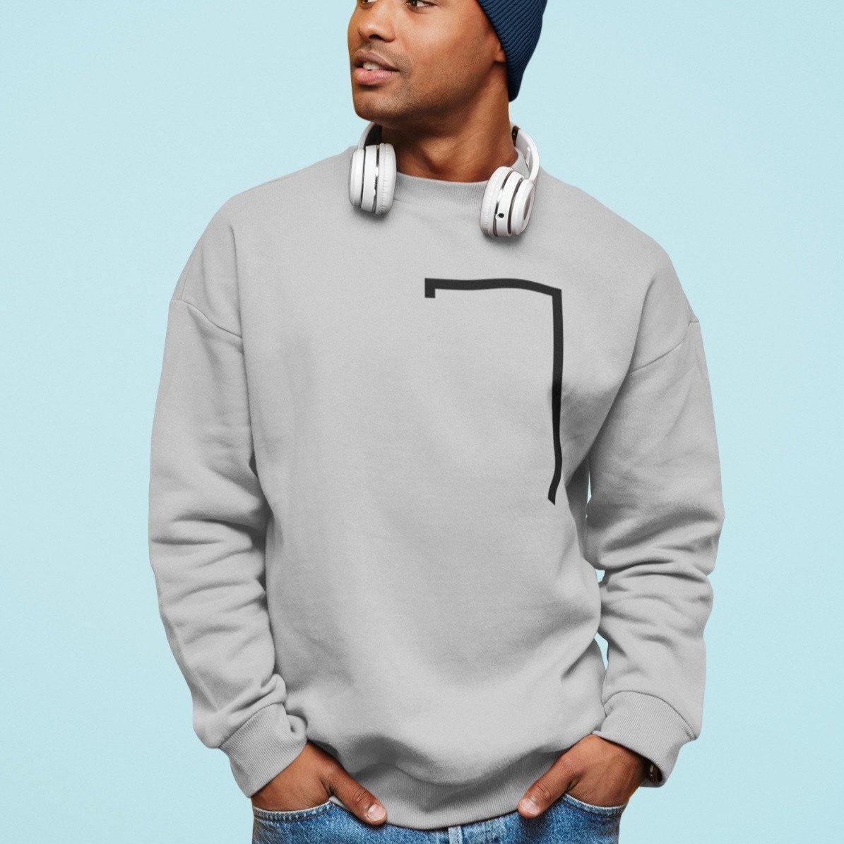 Person wearing a gray sweatshirt with a black design on a light blue background