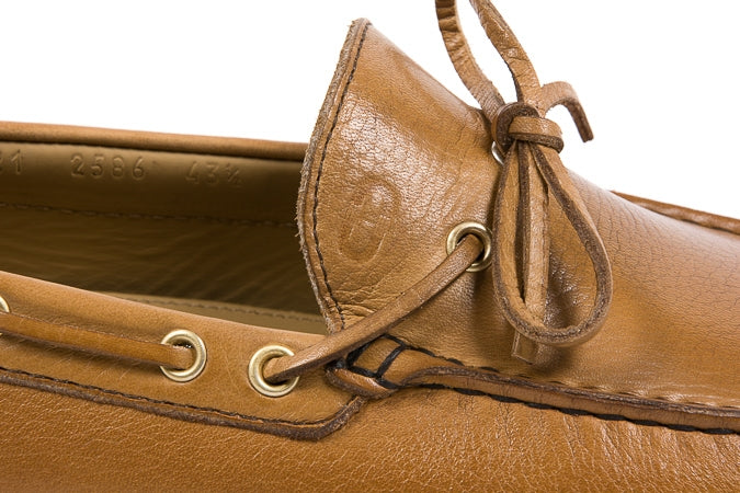 Close-up of a brown leather shoe with a white background