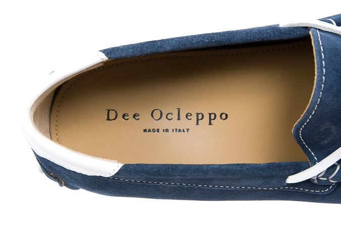 Navy blue shoe with white sole displaying 'Dee Ocleppo' branding on a white background