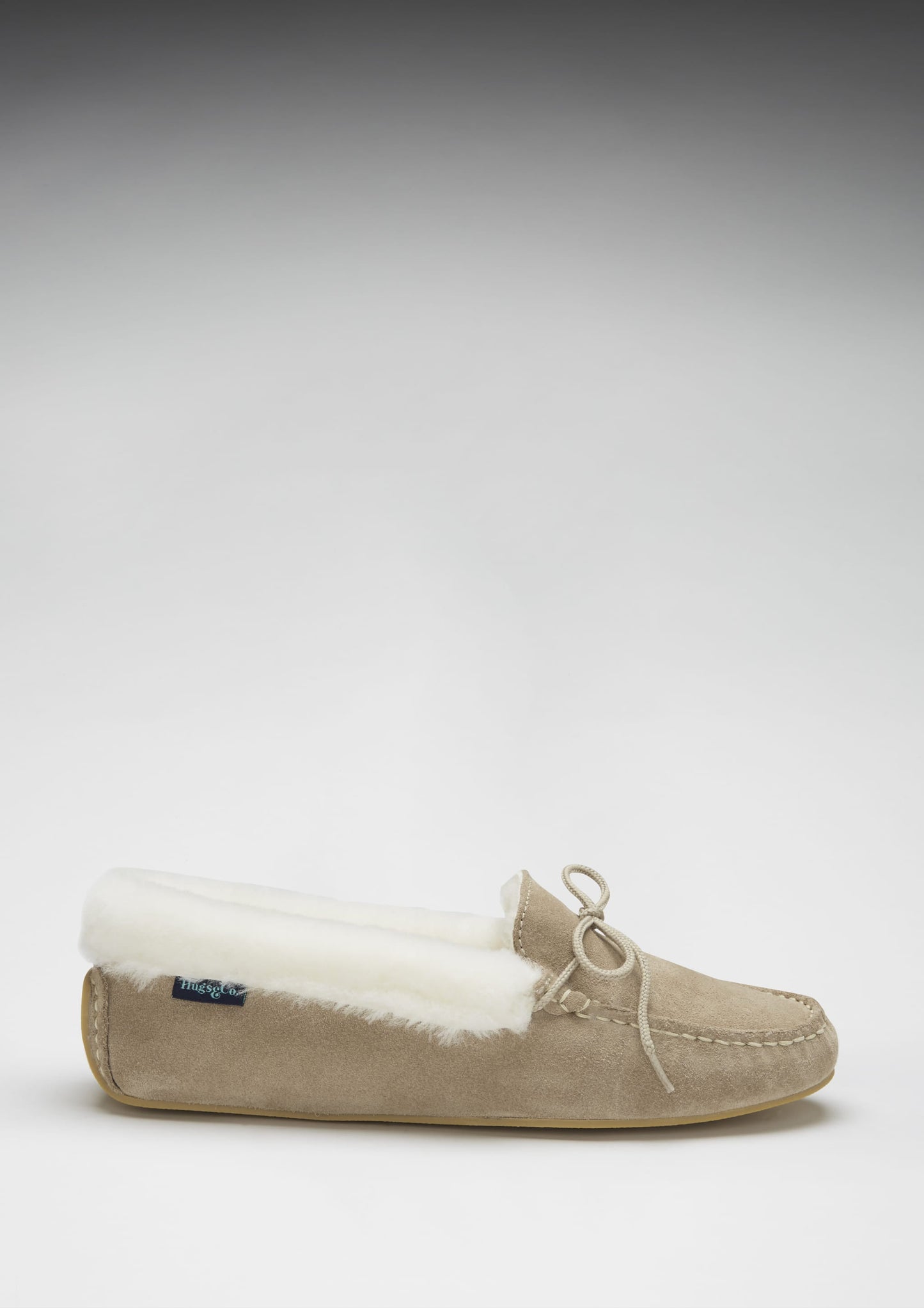 Beige slipper with white fur lining on a light gray background