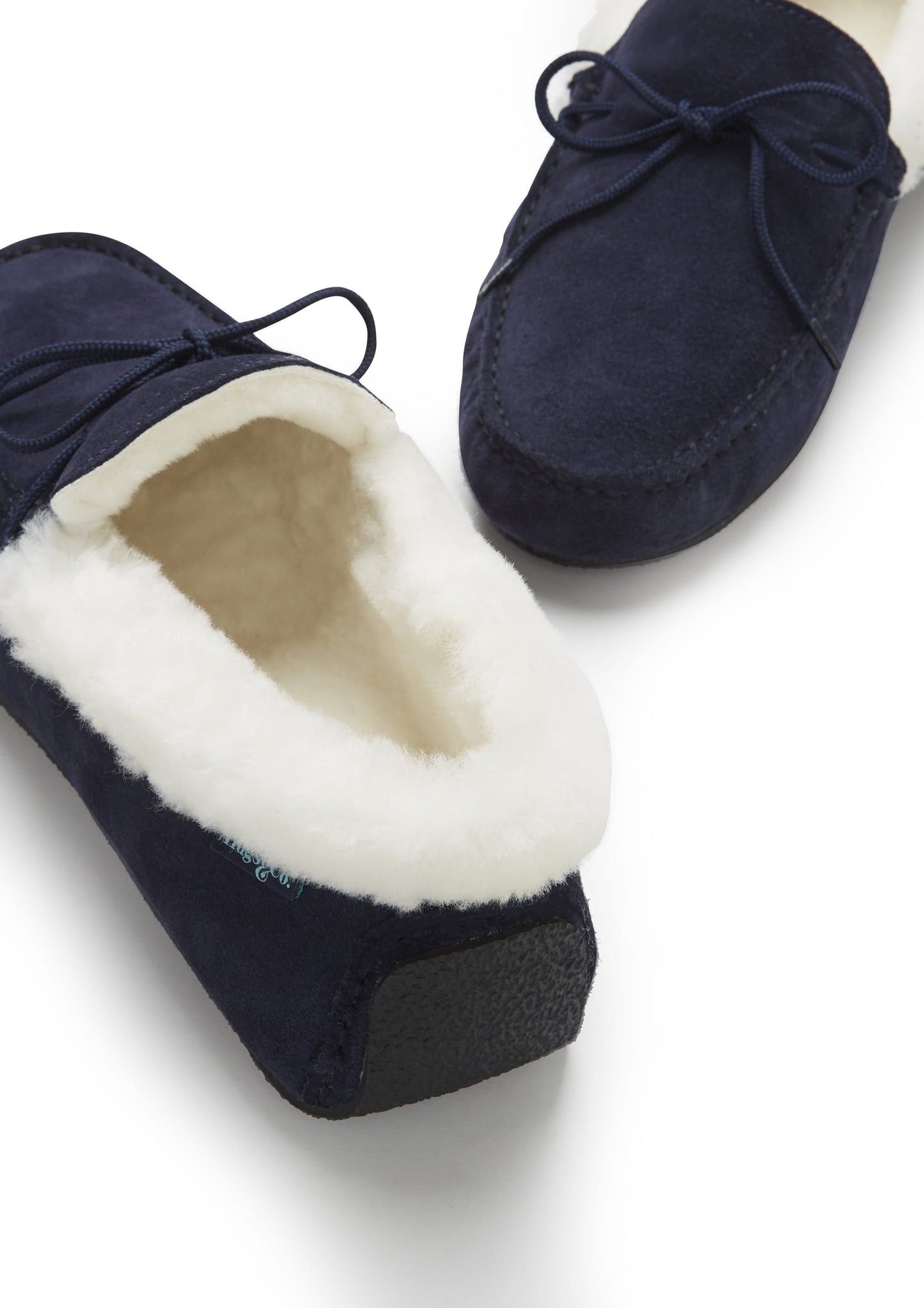 Navy blue slippers with white fur lining on a light gray background