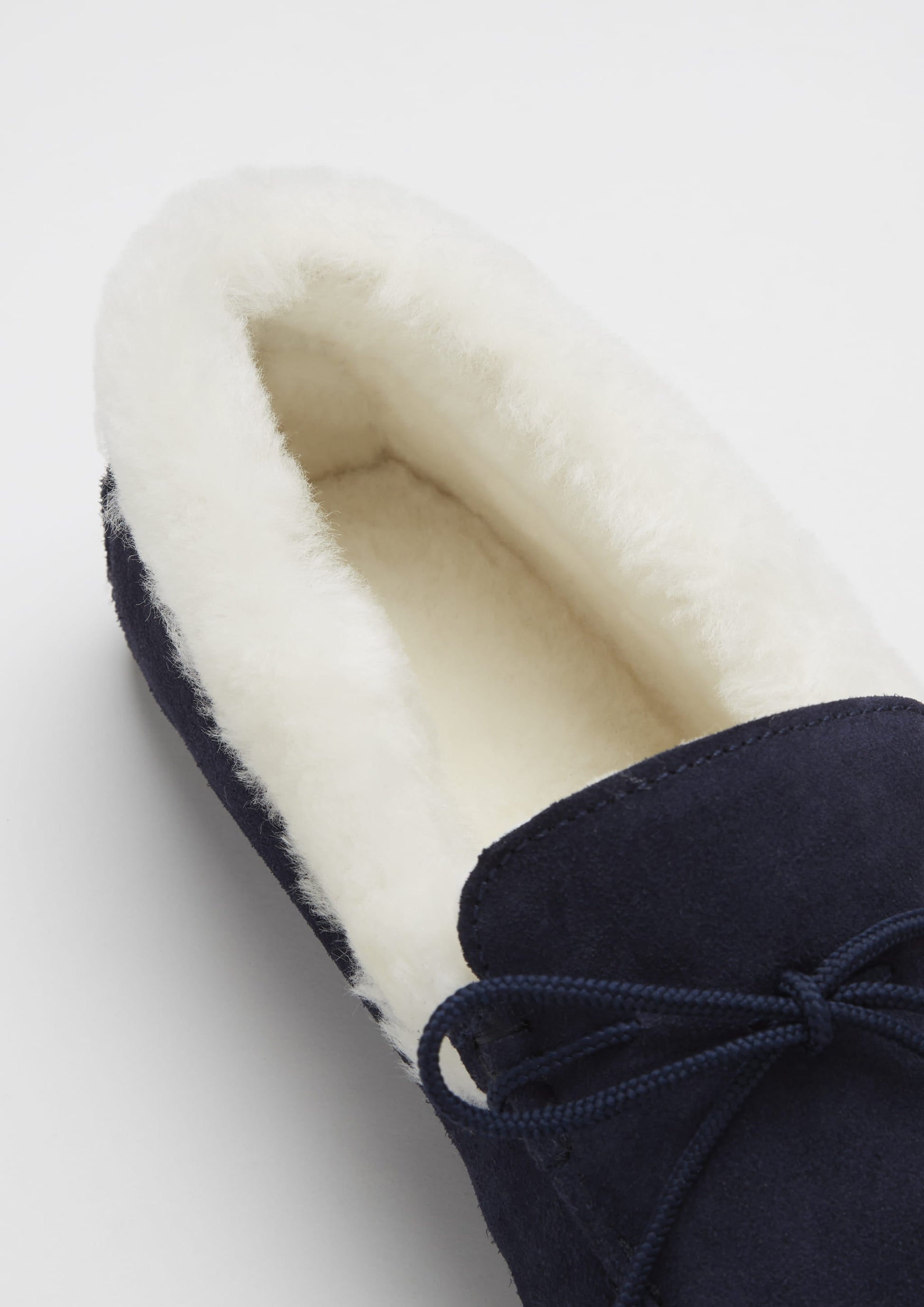 Navy slipper with white lining on a light gray background