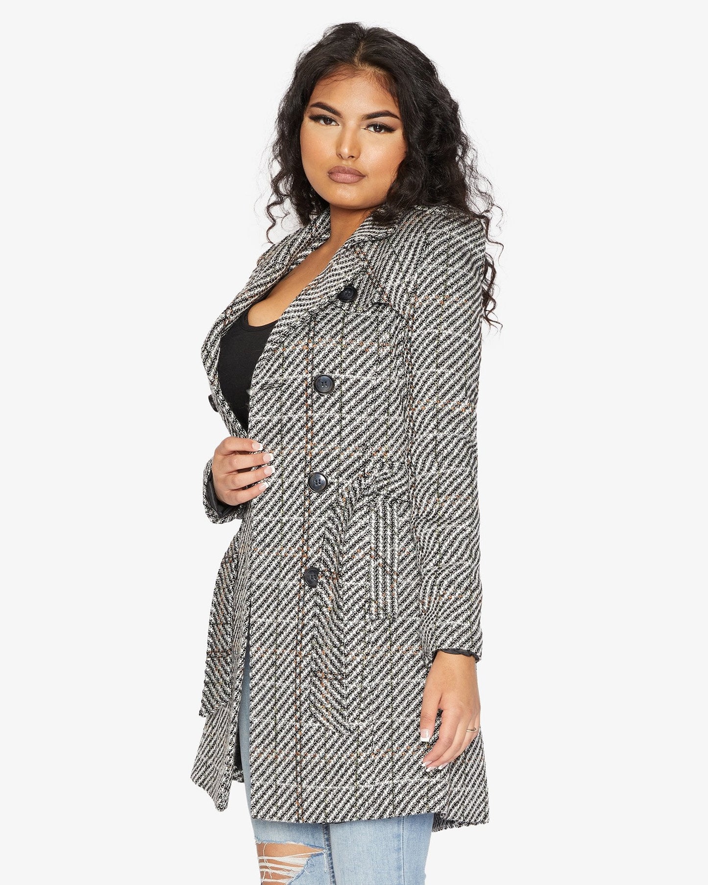 Woman wearing a black and white patterned coat on a white background