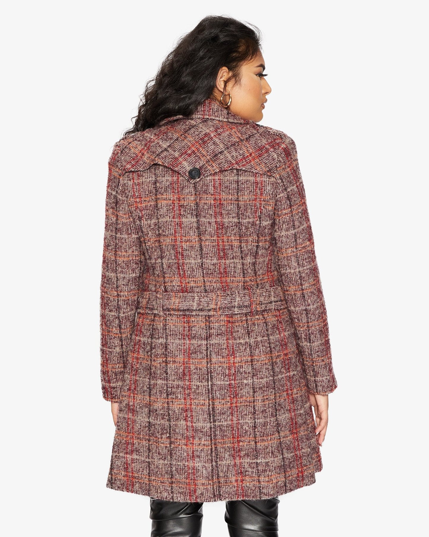 Woman wearing a plaid coat on a white background