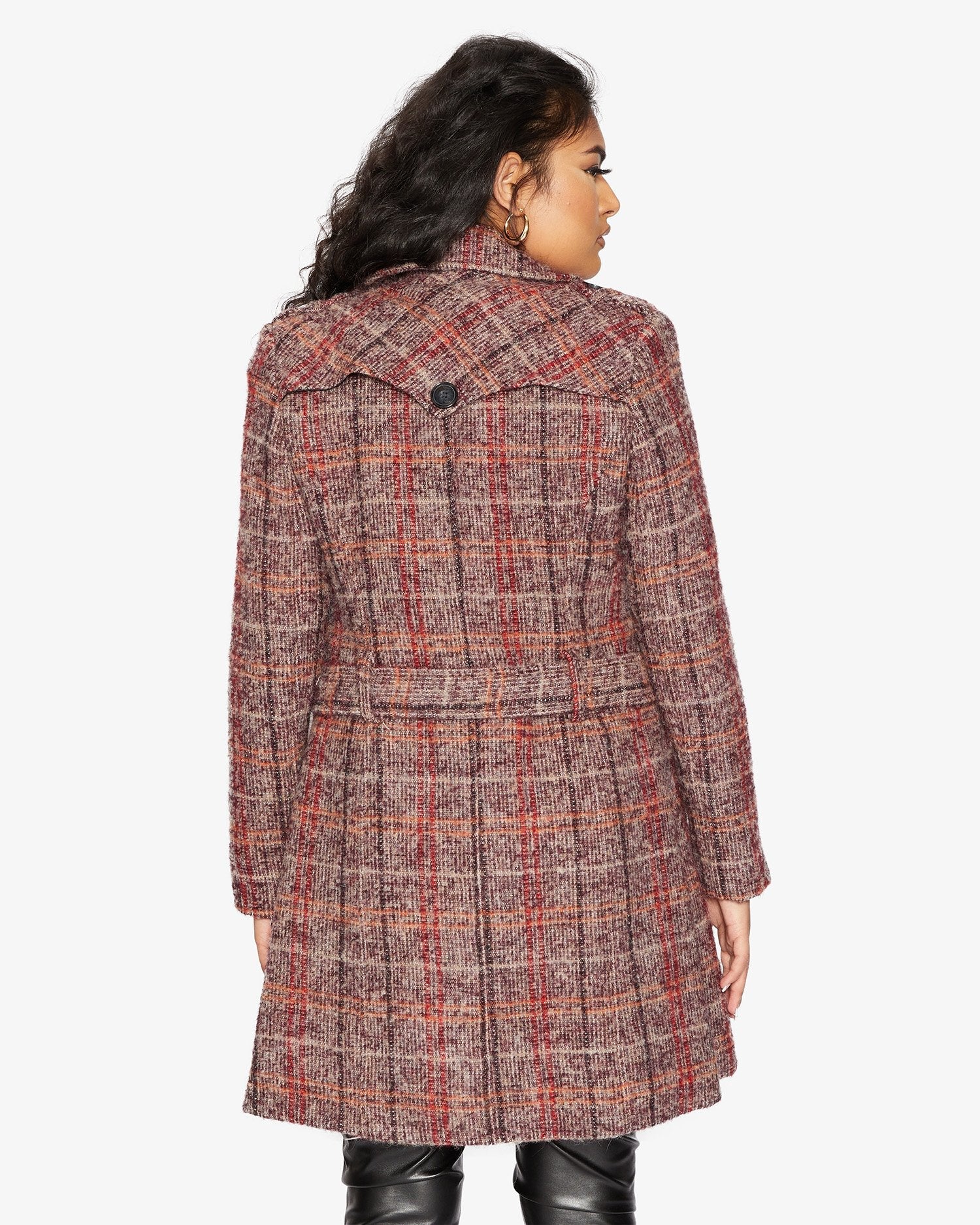 Woman wearing a plaid coat on a white background