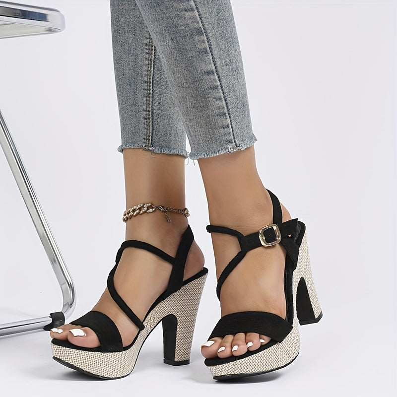 Black strappy high-heeled sandals with textured sole worn with light blue jeans on a white background.