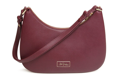Maroon handbag with gold zipper and strap on a white background