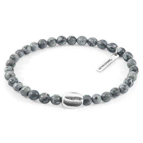 Gray beaded bracelet with silver tag on a white background