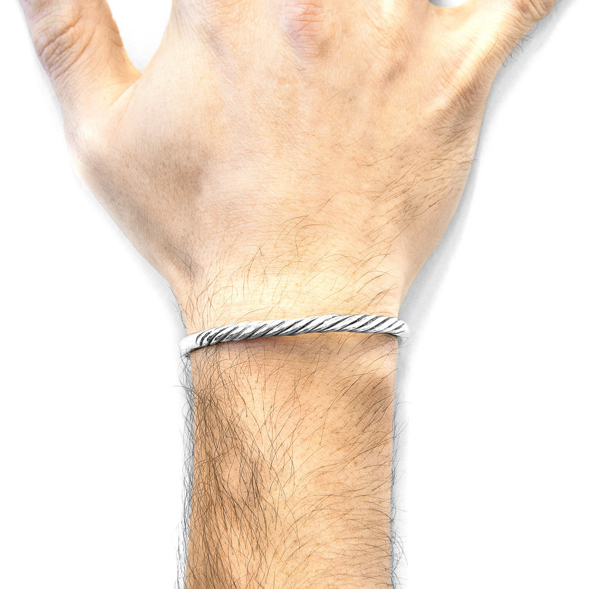 Hand wearing a silver bracelet on a white background