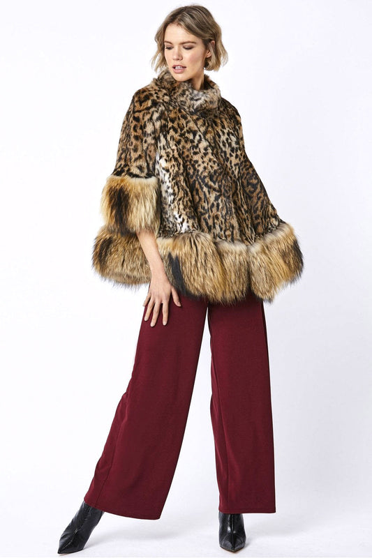 Woman wearing a leopard print fur coat with ruffled edges on a white background