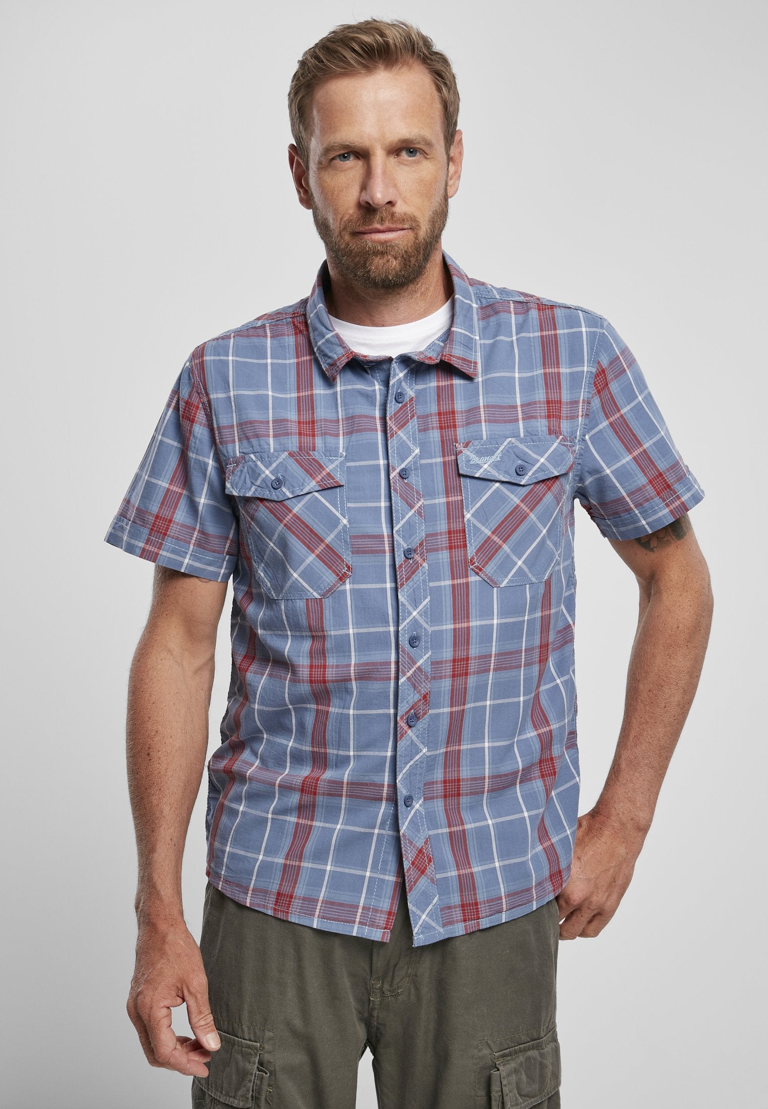 Man wearing a blue plaid shirt with a white background