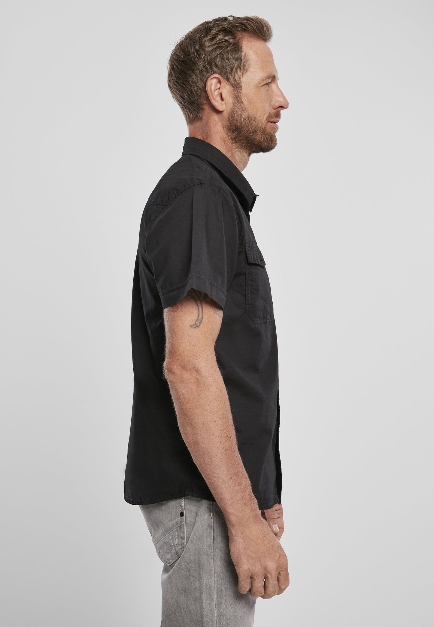 Man wearing a black short-sleeve shirt on a white background
