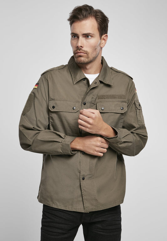 Man wearing a green military-style jacket on a light gray background
