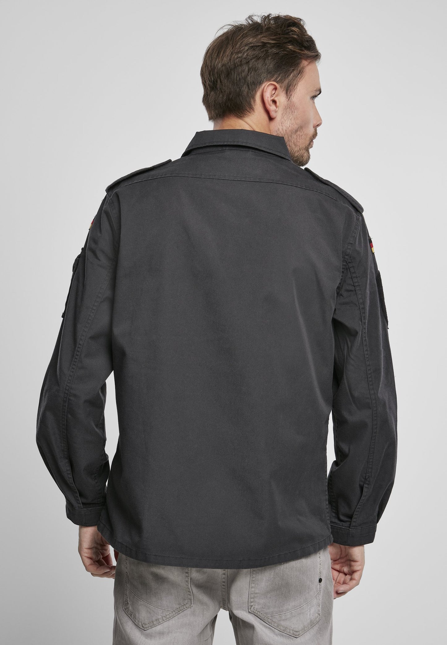 Man wearing a dark gray jacket on a plain background