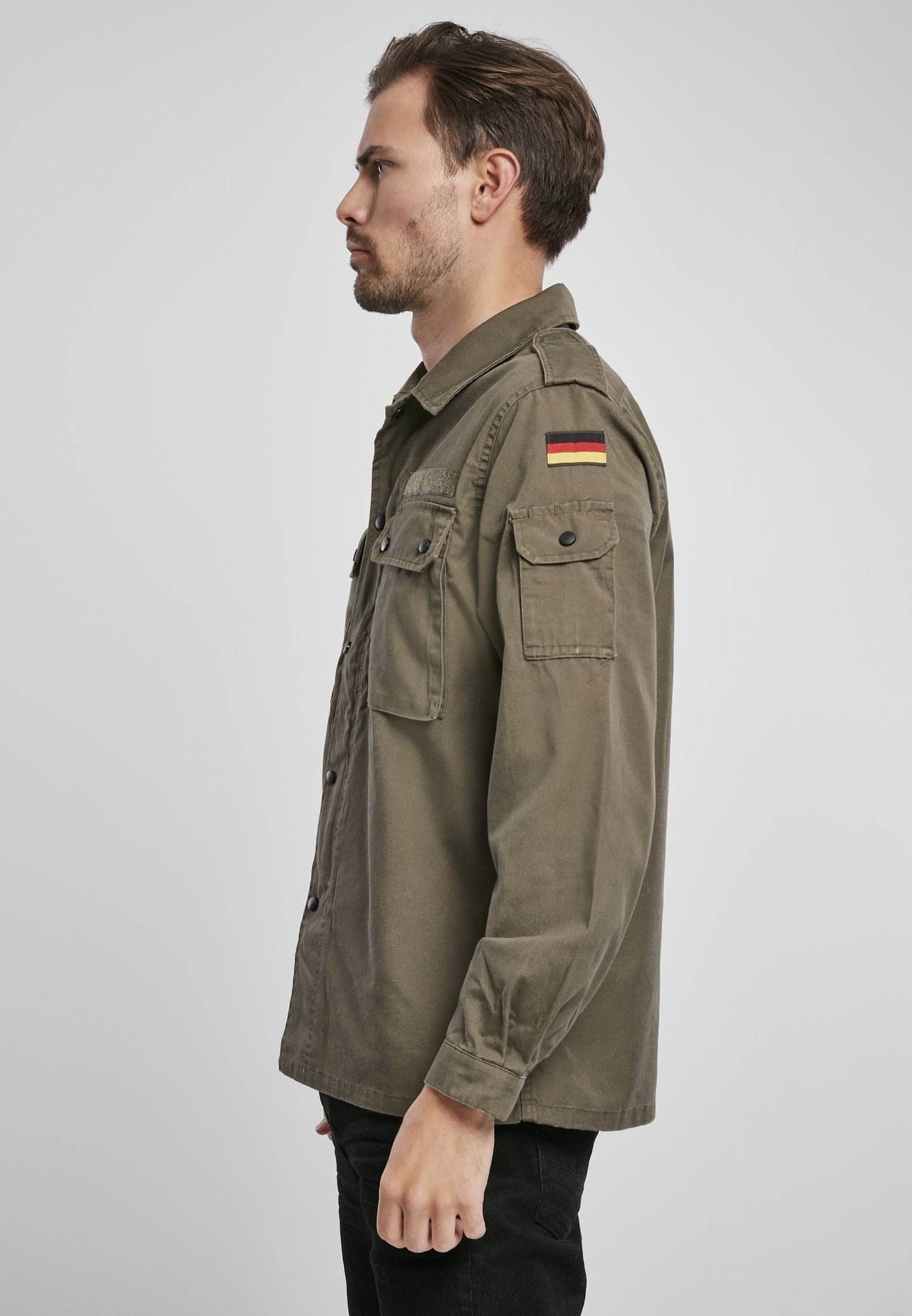 Man wearing a green jacket with a German flag patch on a white background