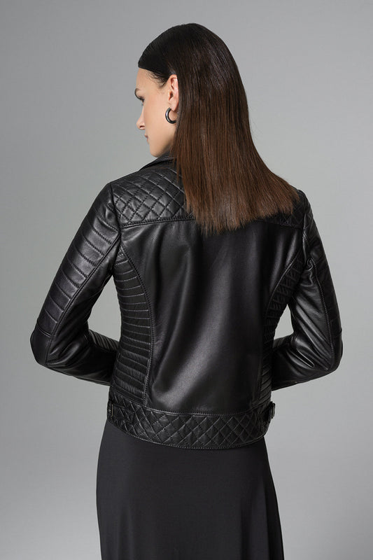 Woman wearing a black leather jacket with quilted design on a gray background