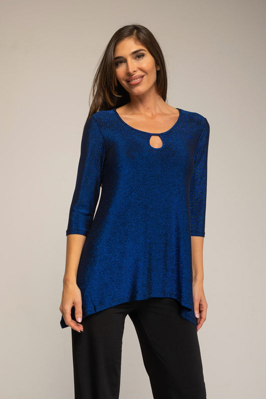 Woman wearing a blue top with a cutout detail on a plain background