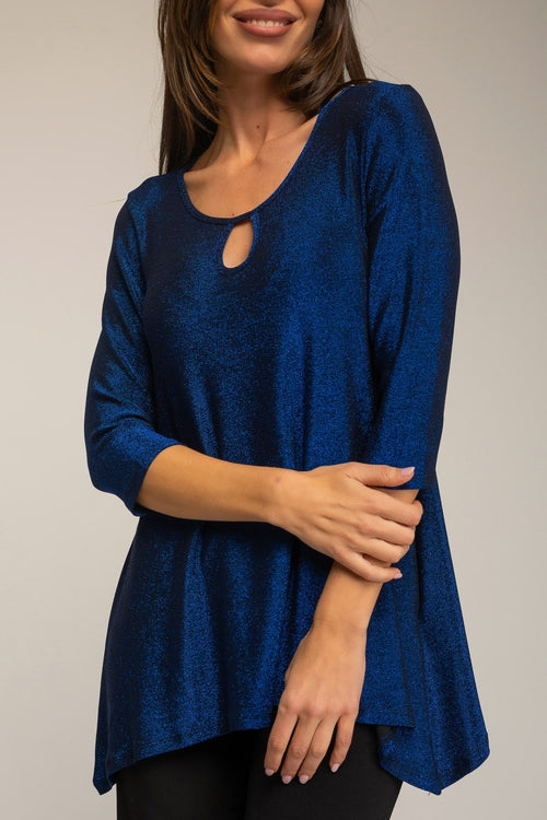 Woman wearing a blue top with a cutout detail on a plain background