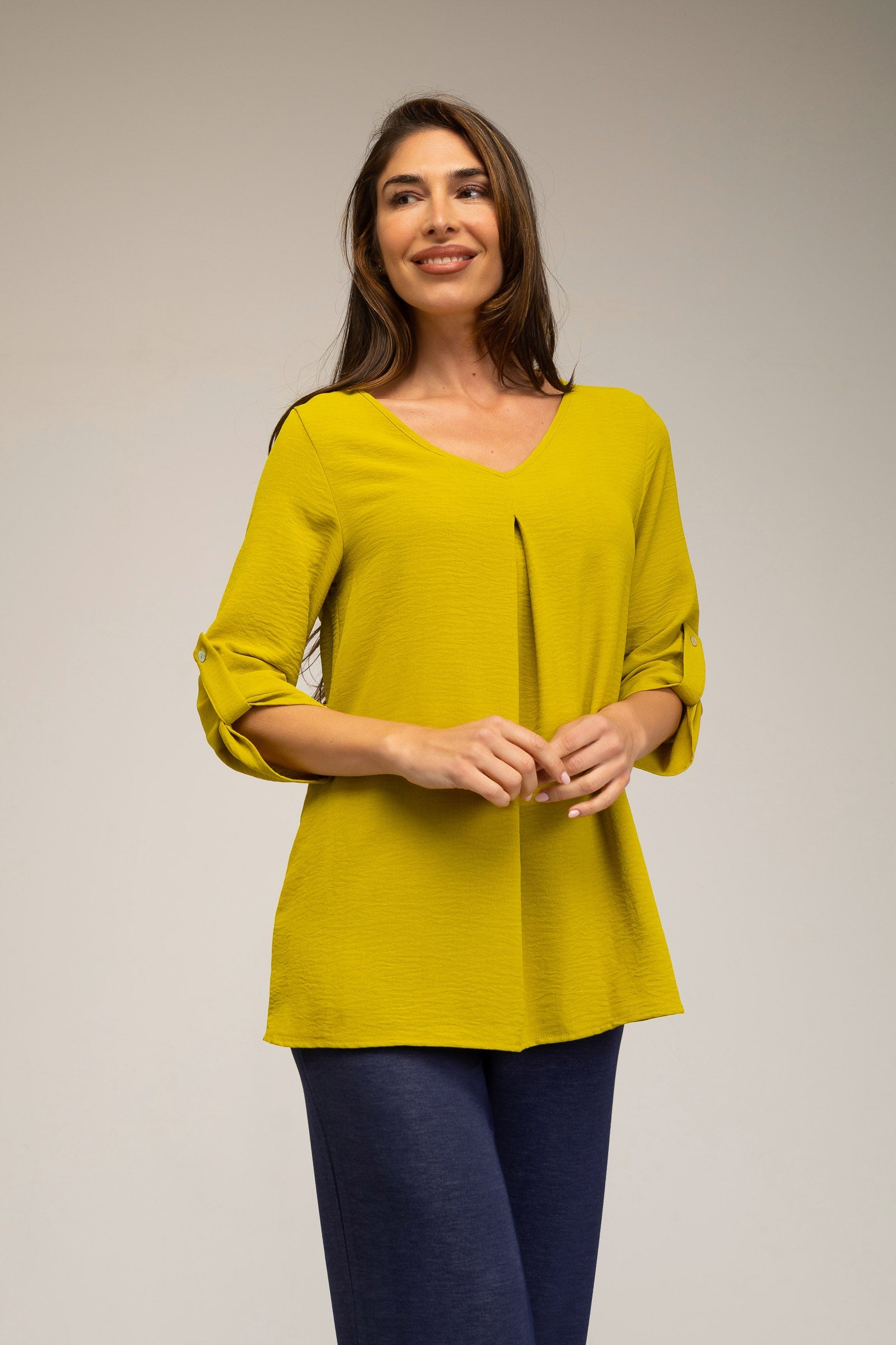 Woman wearing a yellow blouse against a plain background