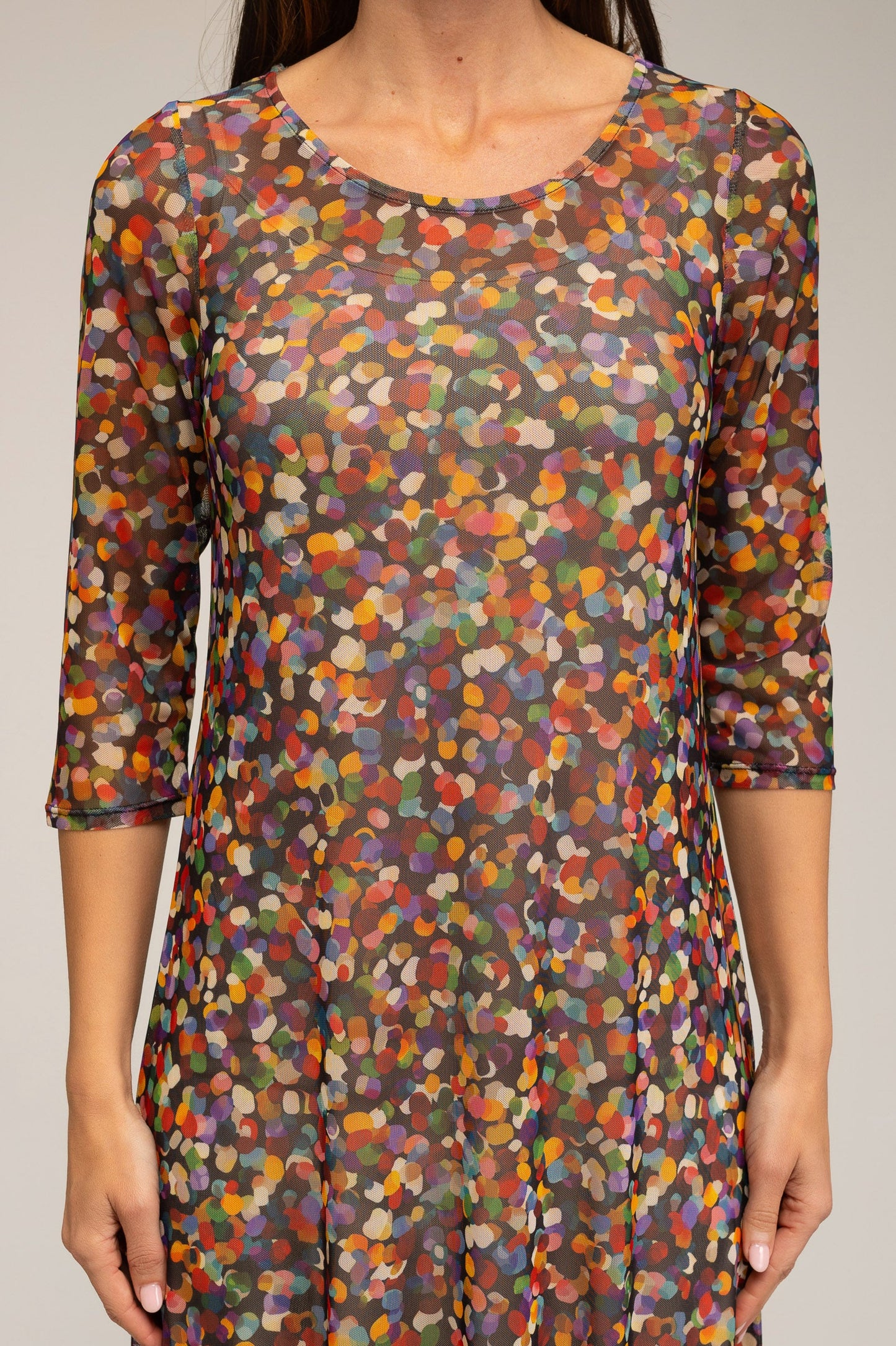Multicolored patterned dress worn by a person against a neutral background