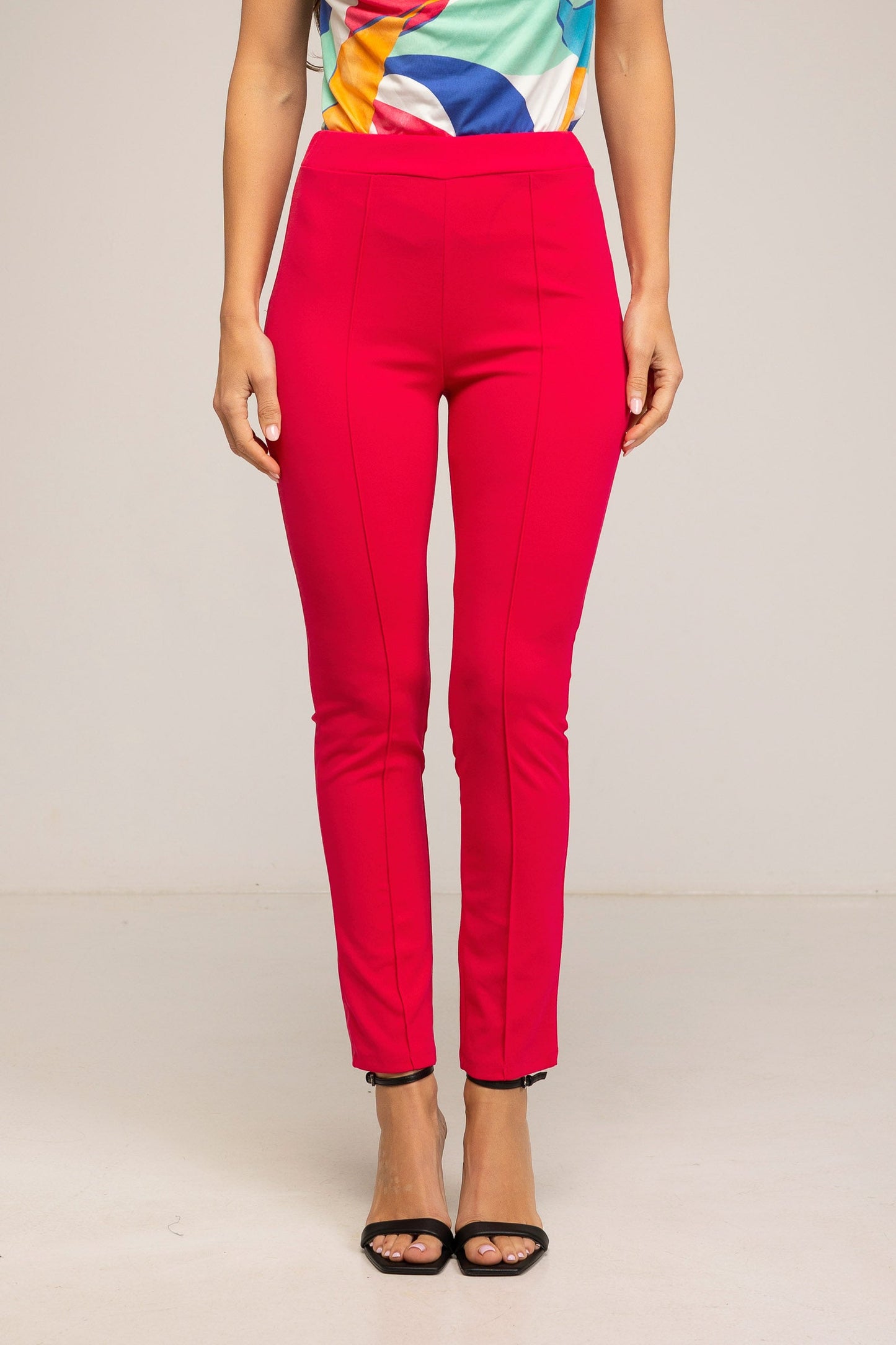 Red pants worn by a person on a plain background